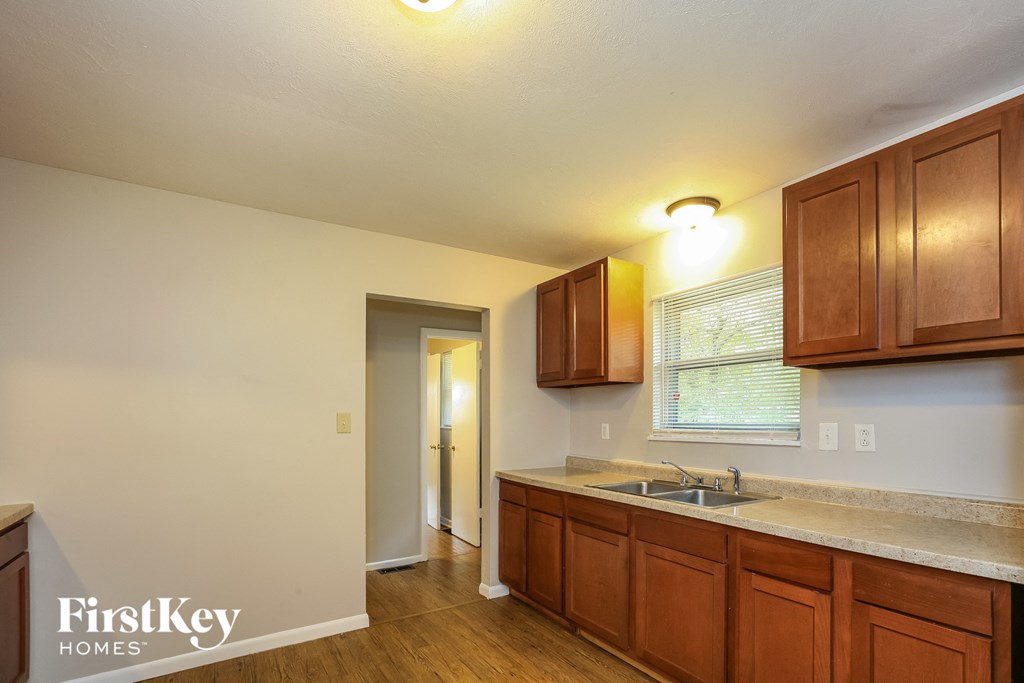 an empty kitchen with wooden cabinets and a sink