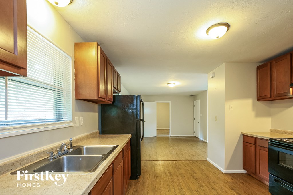 a kitchen with a large window and a sink and a refrigerator
