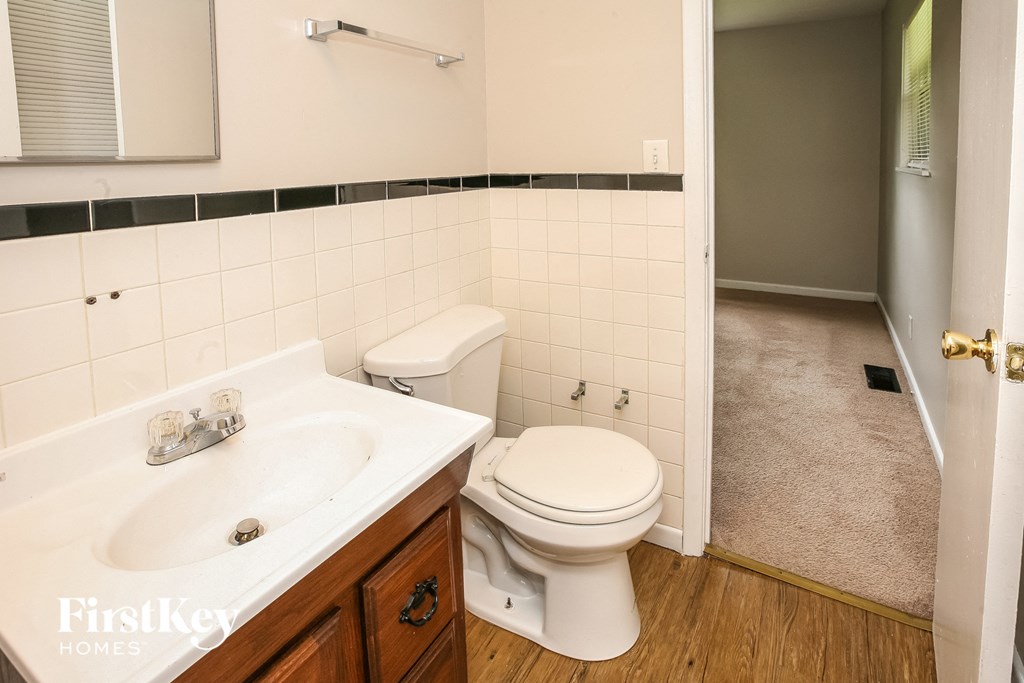 a bathroom with a toilet and a sink and a mirror