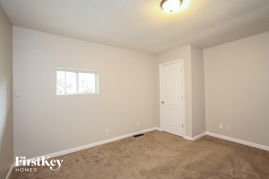 a bedroom with a carpeted floor and a white door