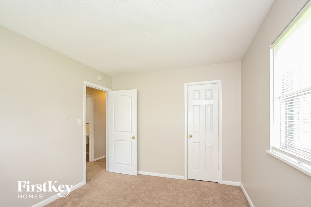 a bedroom with two white doors and a door to a closet