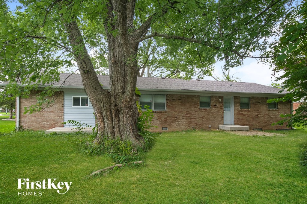 a small brick house with a tree in front of it