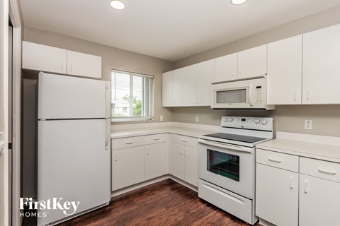 a white kitchen with white appliances and white cabinets