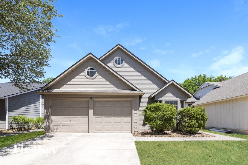 a house with a garage door and a lawn
