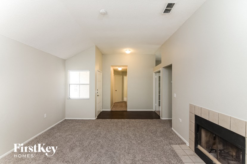 a living room with a fireplace and a carpeted floor
