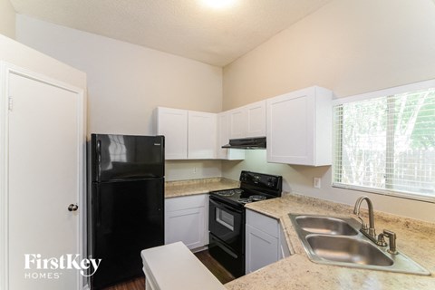 a kitchen with black appliances and white cabinets