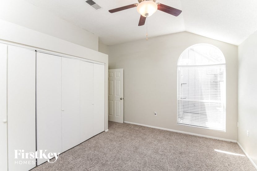 a bedroom with a ceiling fan and a closet