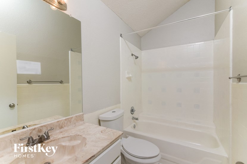 a white bathroom with a tub and a sink and a toilet