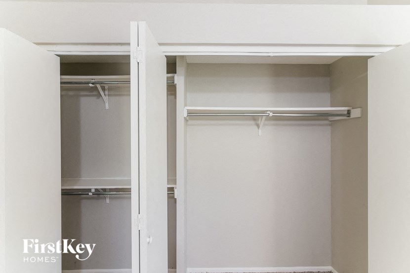 an empty closet with the door open and the closet doors open