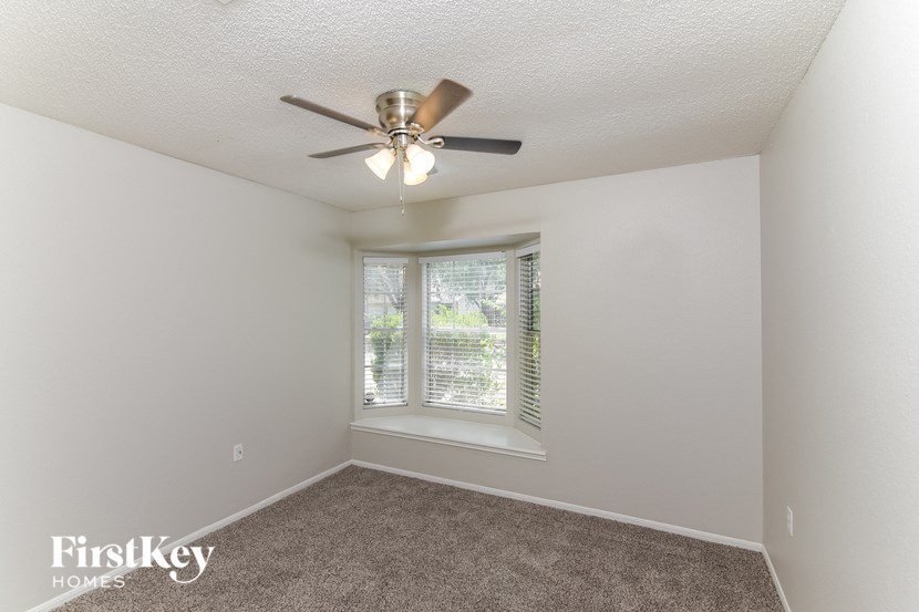 a bedroom with a ceiling fan and a window