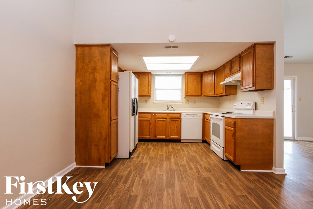 A kitchen with wooden cabinets and a white refrigerator.