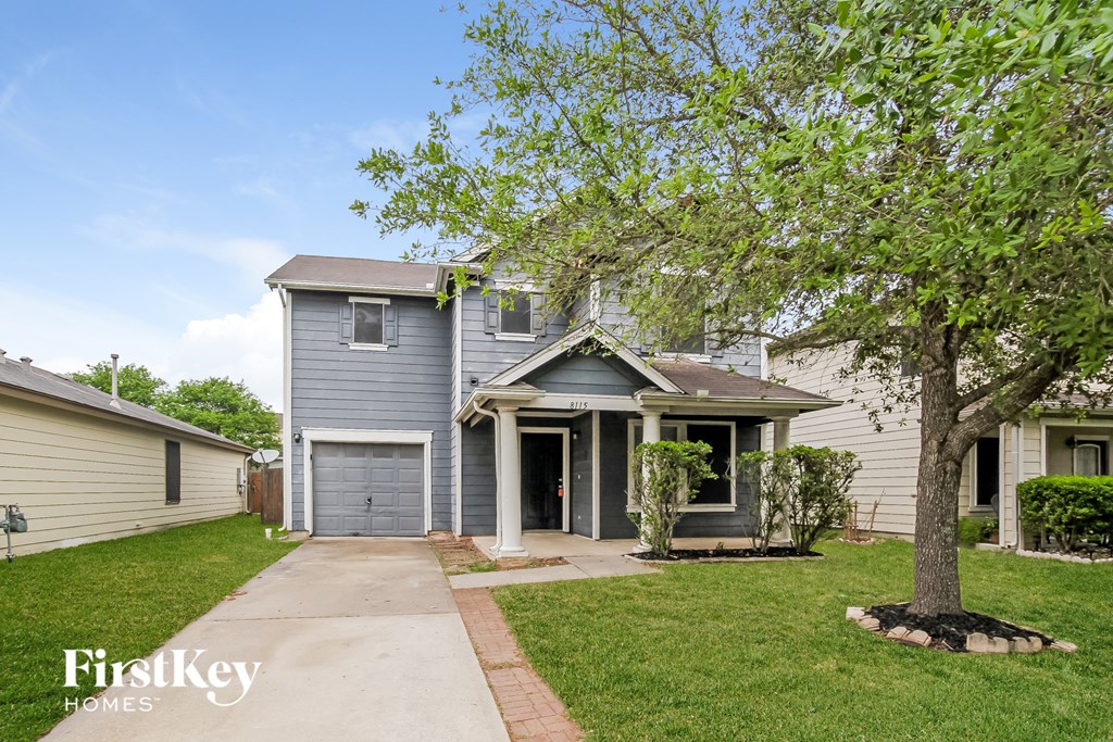 a blue house with a tree in the front yard