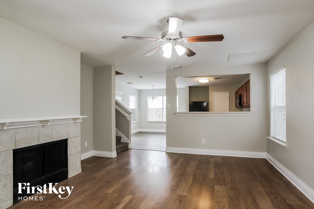 a living room with a fireplace and a ceiling fan