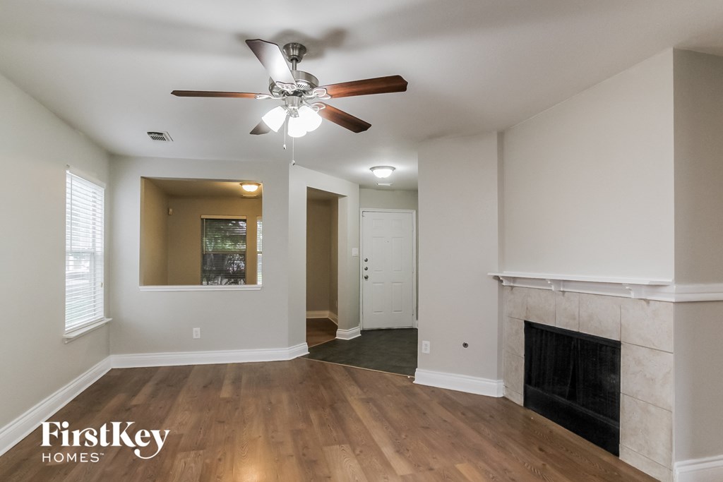 a living room with a ceiling fan and a fireplace