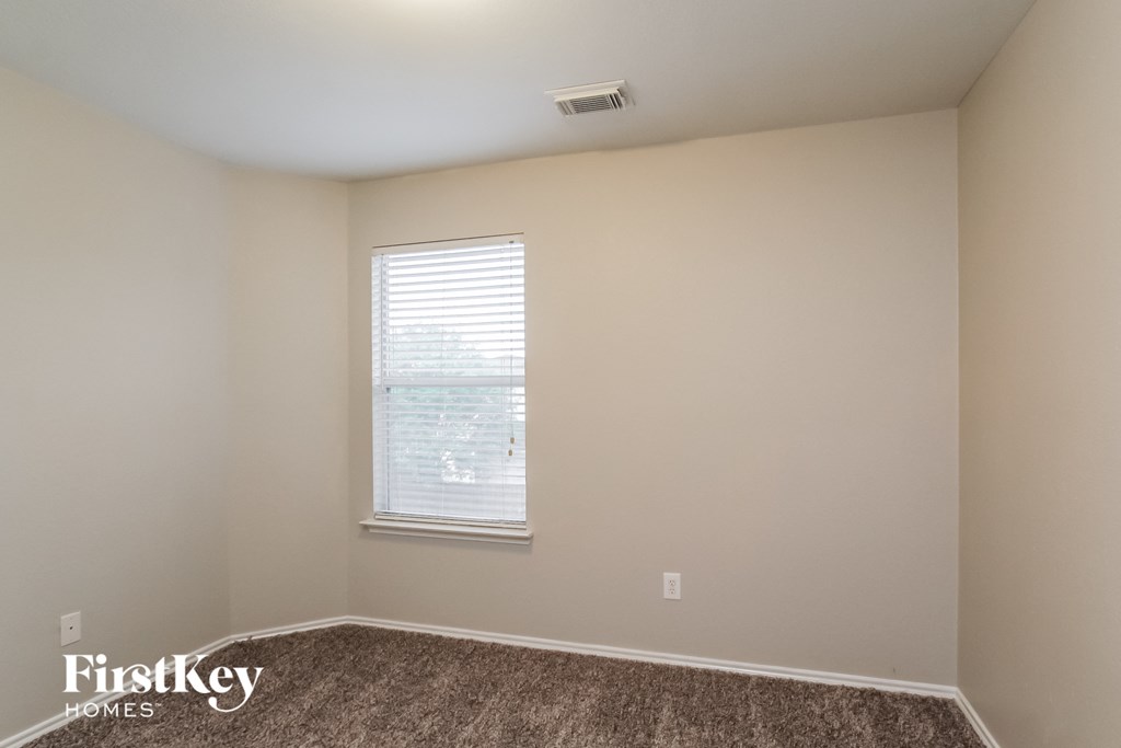 the living room of an apartment with a window and carpet