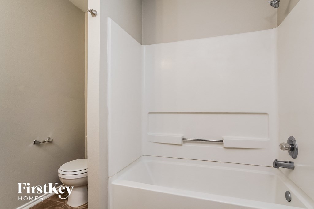 a bathroom with a white tub and a toilet and a sink