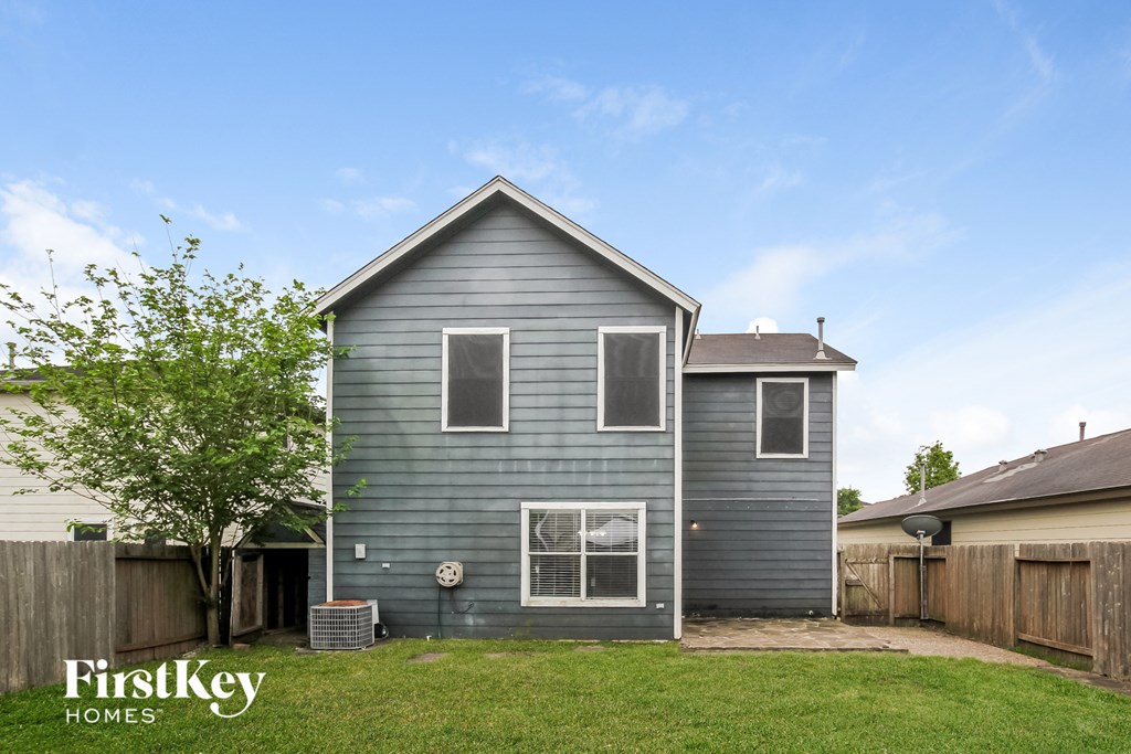 the outside of a blue house with a yard and a tree