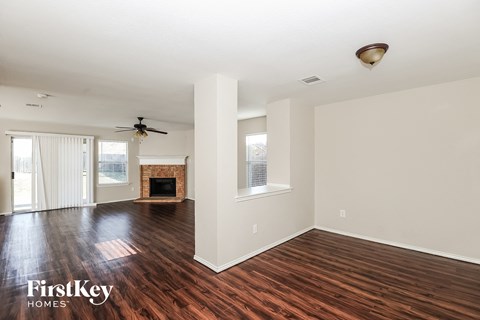 A spacious room with wood flooring and a fireplace is available for rent.