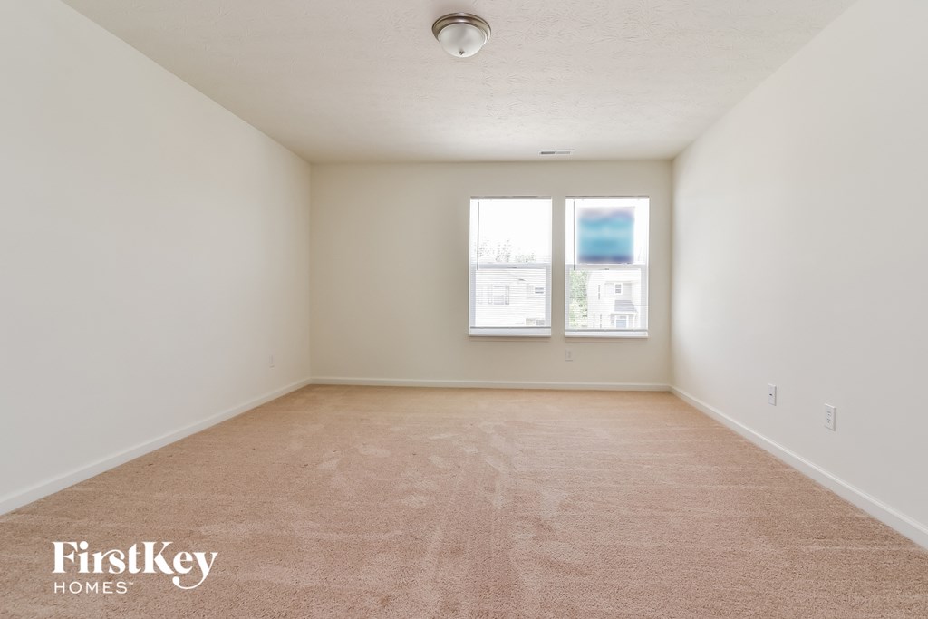 A room with a carpeted floor and a window.