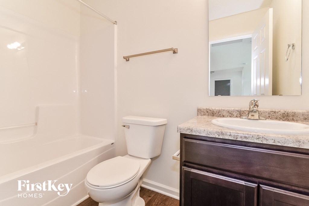 A white toilet sits next to a sink in a bathroom.