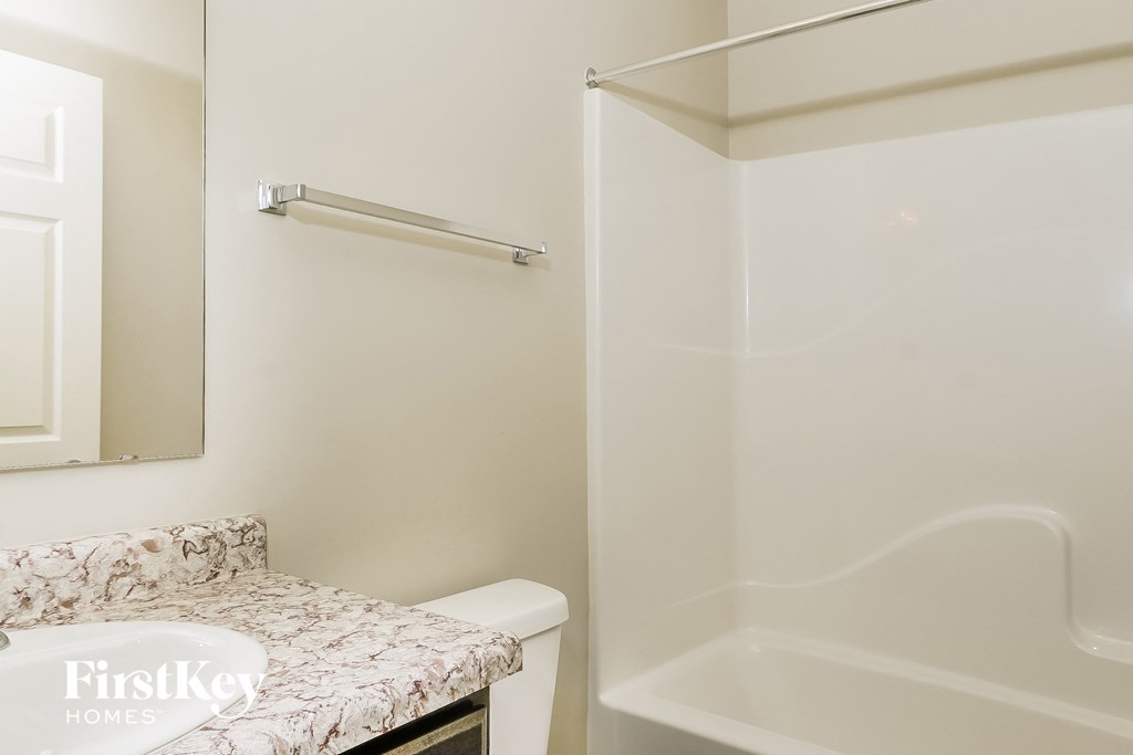 a bathroom with a shower and a sink and a toilet