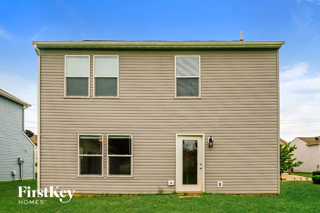 the front of a house with brown siding and green grass