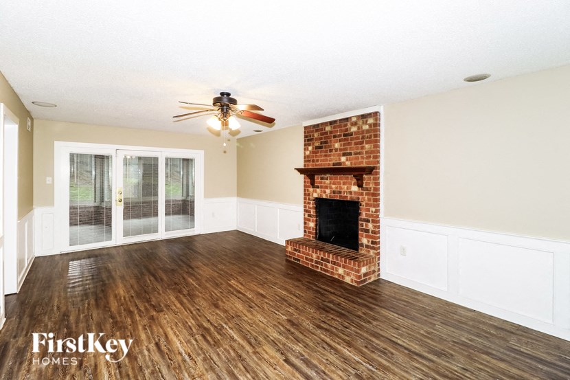 A room with a fireplace and a ceiling fan.