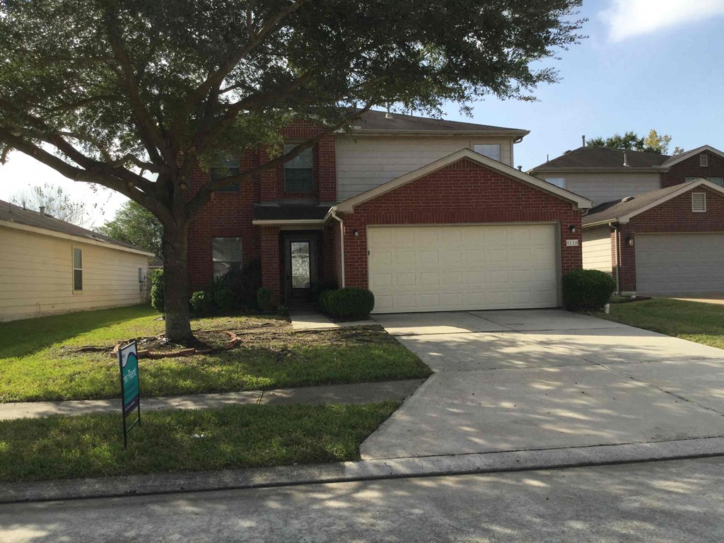 A house with a red brick facade and a white garage door.