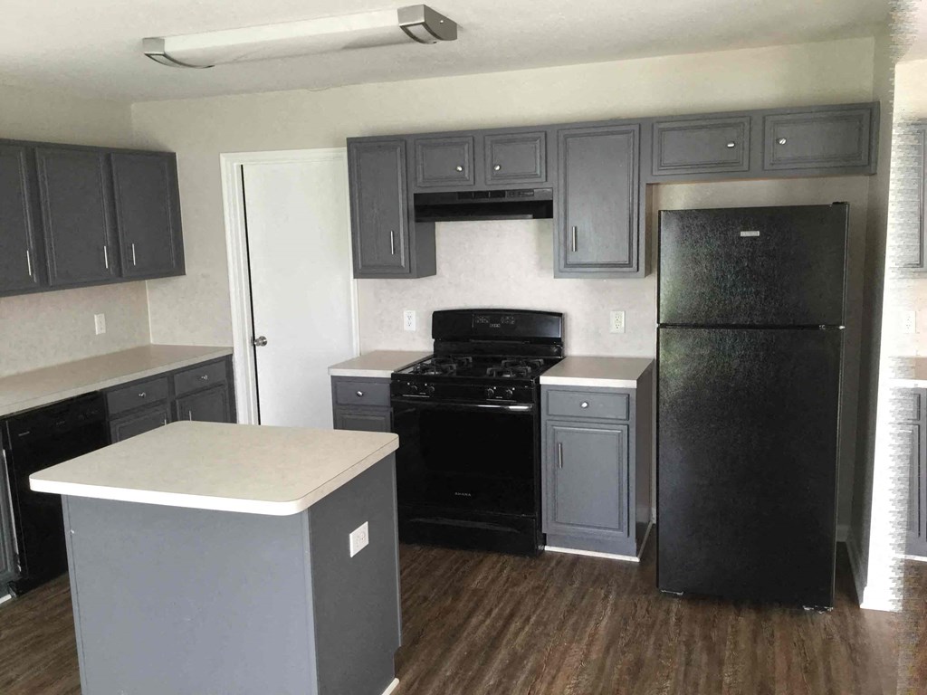 A kitchen with black appliances and cabinets.
