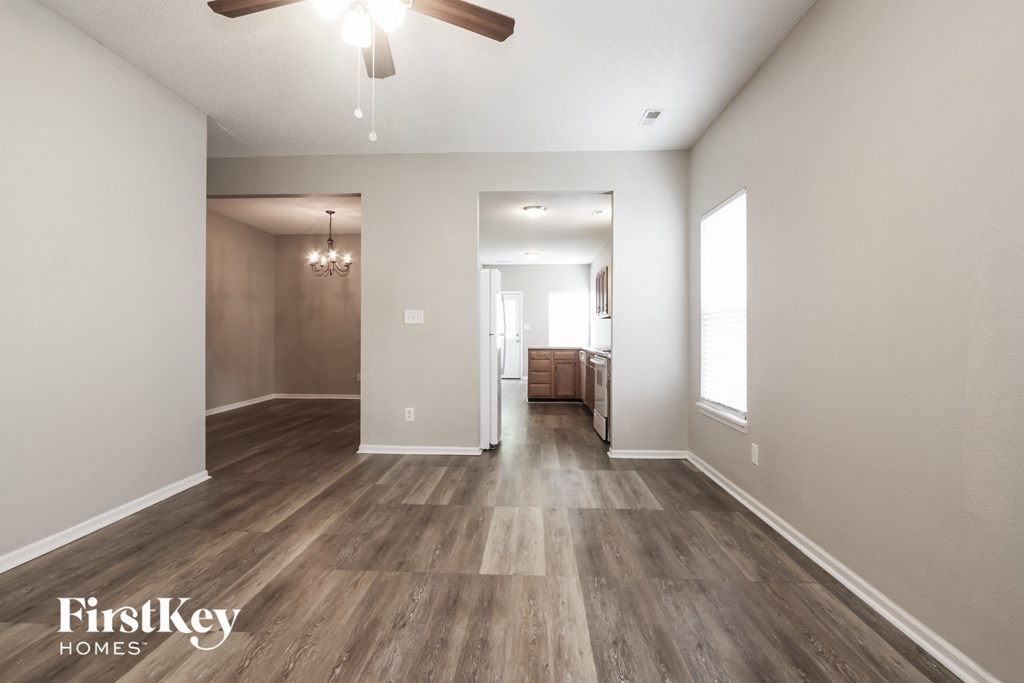 the living room and dining room with hardwood flooring and a ceiling fan