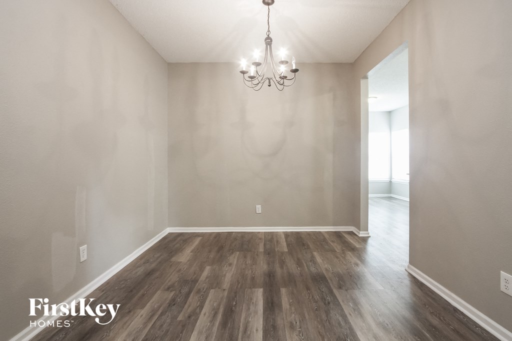 the spacious living room with wood floors and a chandelier