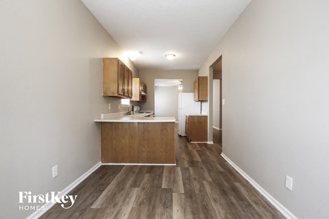 a kitchen with wood flooring and white walls and wooden cabinets