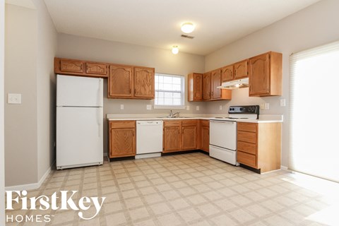 A kitchen with wooden cabinets and a white refrigerator.