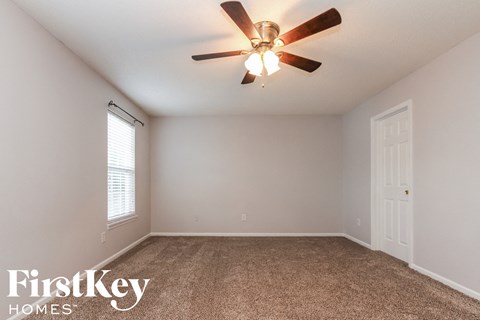 A room with a ceiling fan and a window.