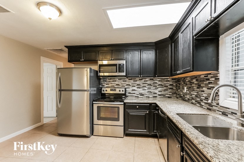 A kitchen with a stainless steel refrigerator, oven, and microwave.