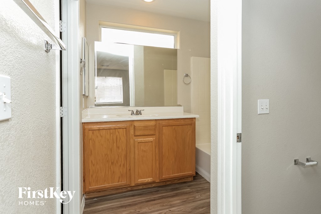 a bathroom with wooden cabinets and a sink and a mirror