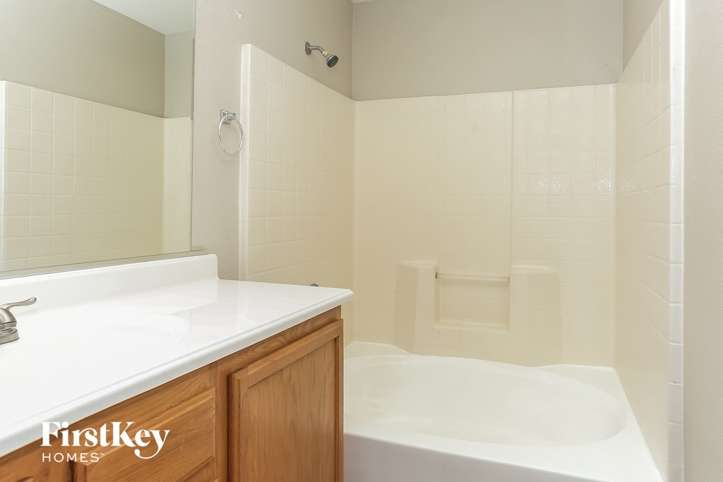 a bathroom with a tub and a sink and a mirror