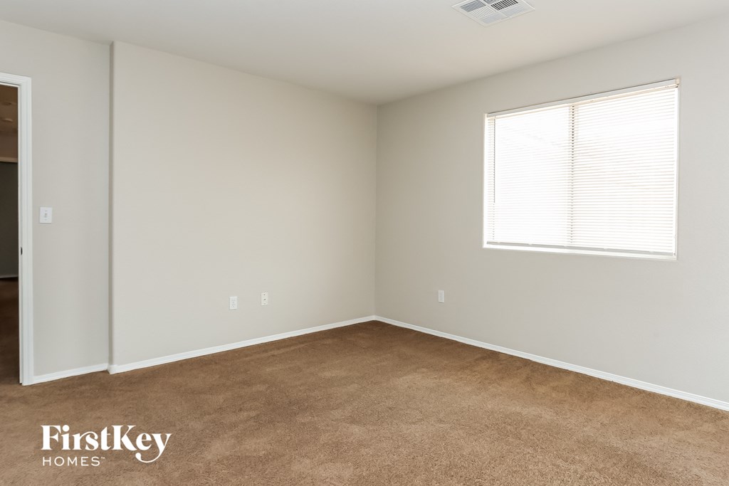 a bedroom with a carpeted floor and a window