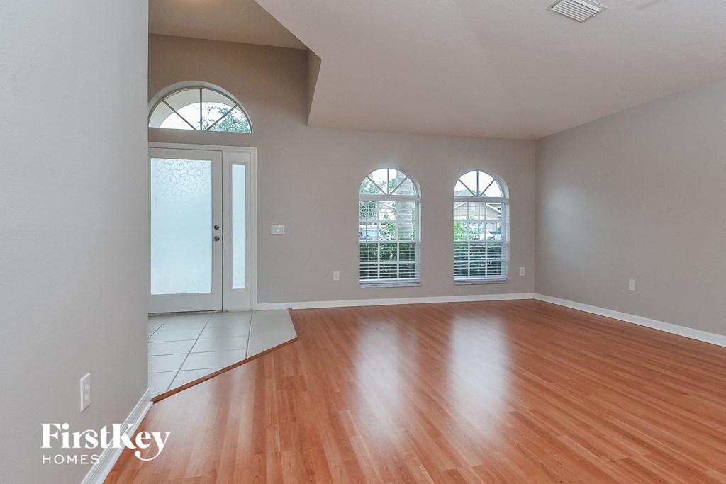 an empty living room with wood floors and windows