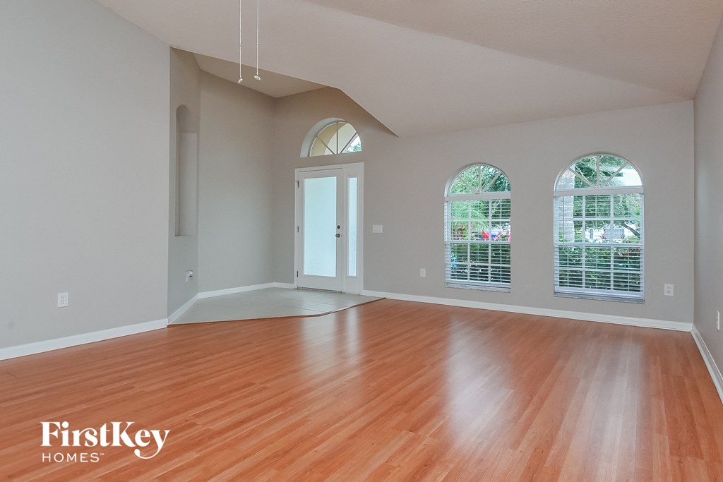 an empty living room with wood floors and windows