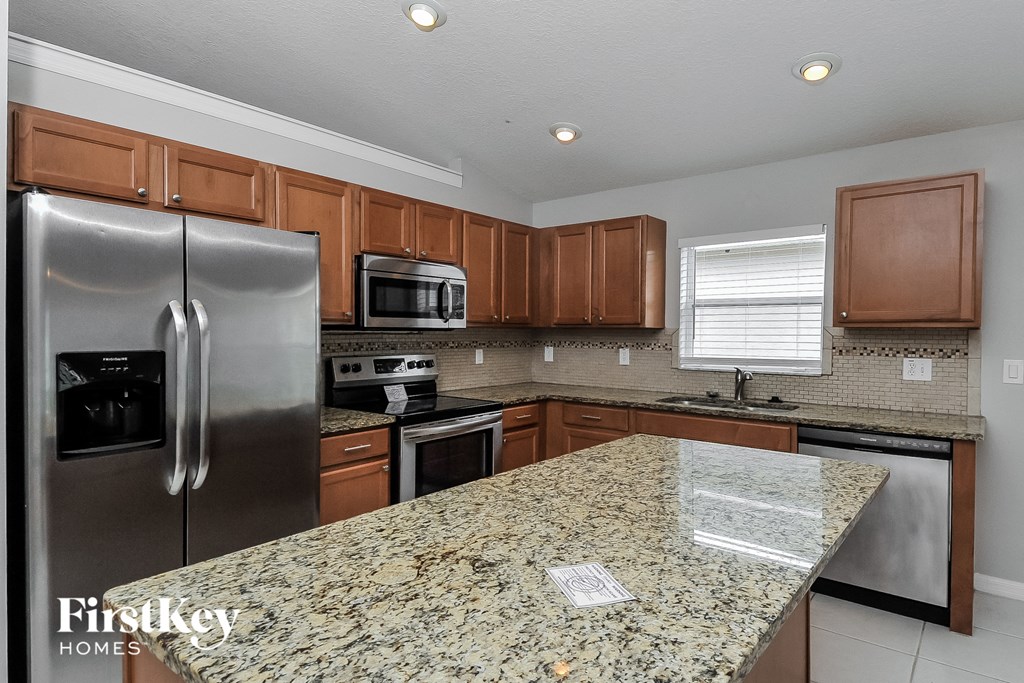 a kitchen with granite countertops and stainless steel appliances