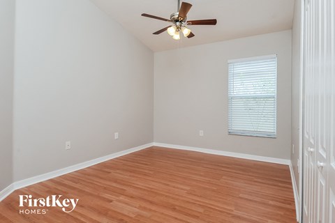 a bedroom with hardwood flooring and a ceiling fan