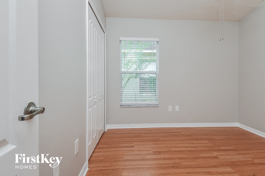 an empty room with wood floors and a window