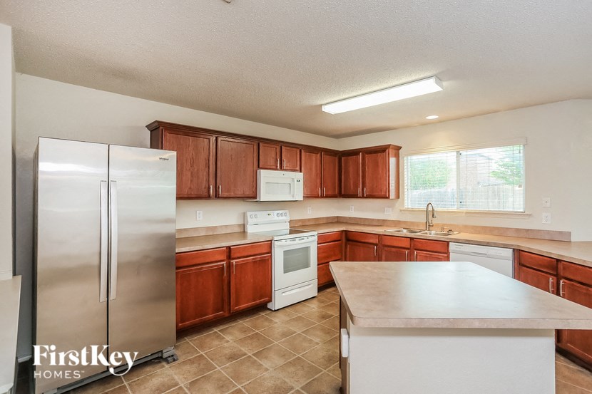 a kitchen with wooden cabinets and white appliances and a stainless steel refrigerator