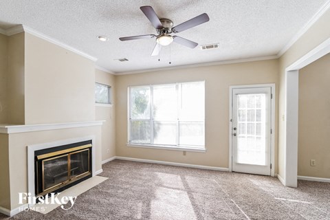 a living room with a fireplace and a ceiling fan