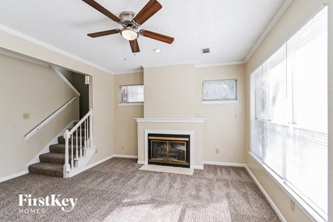 a living room with a fireplace and a ceiling fan