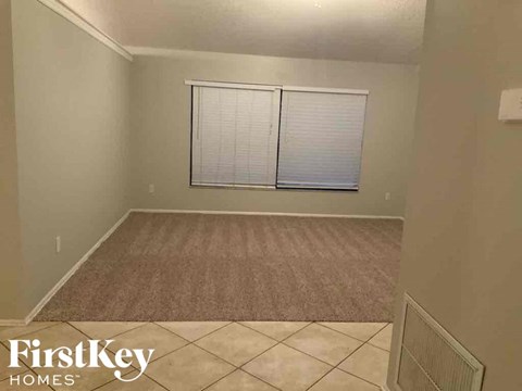 an empty living room with a window and a rug