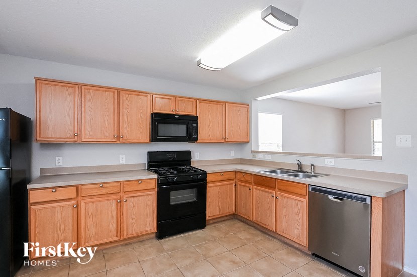 a kitchen with wooden cabinets and black appliances