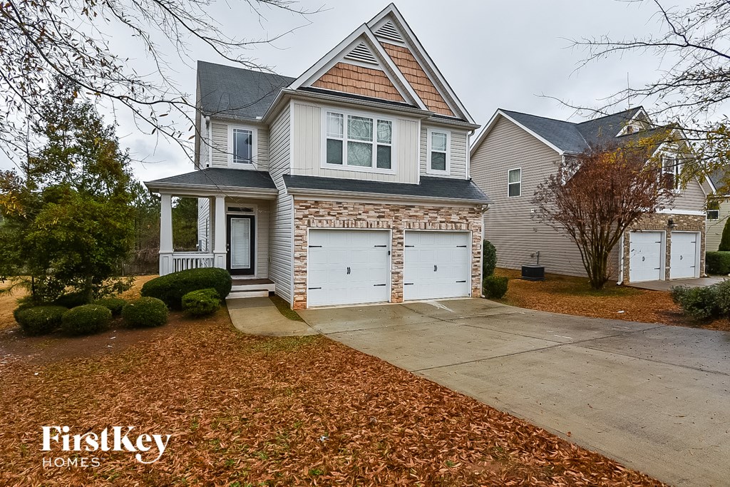 A house with a garage and a driveway in front of it.