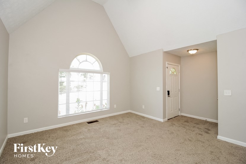 a bedroom with a large window and a carpeted floor